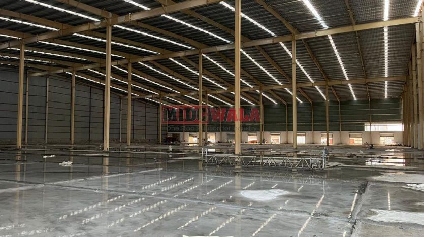 spacious and well-maintained industrial shed available for lease in Bhiwandi Thane Mumbai's TTC Industrial Area. The shed features ample workspace, ample power supply, and convenient access to transportation.