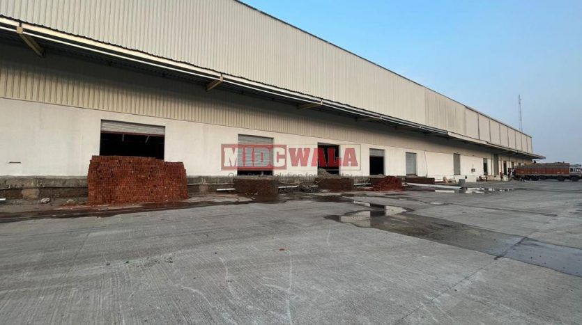 spacious and well-maintained industrial shed available for lease in Bhiwandi Thane Mumbai's TTC Industrial Area. The shed features ample workspace, ample power supply, and convenient access to transportation.