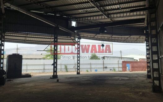 Alternative Text: Industrial shed for lease in Taloja Wavanje, Navi Mumbai. Large metal building with loading dock doors.