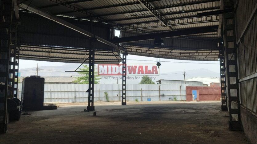 Alternative Text: Industrial shed for lease in Taloja Wavanje, Navi Mumbai. Large metal building with loading dock doors.