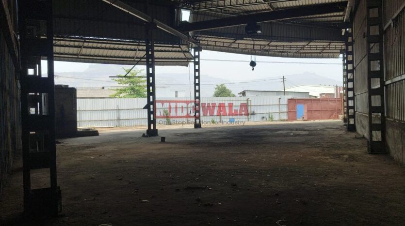 Alternative Text: Industrial shed for lease in Taloja Wavanje, Navi Mumbai. Large metal building with loading dock doors.