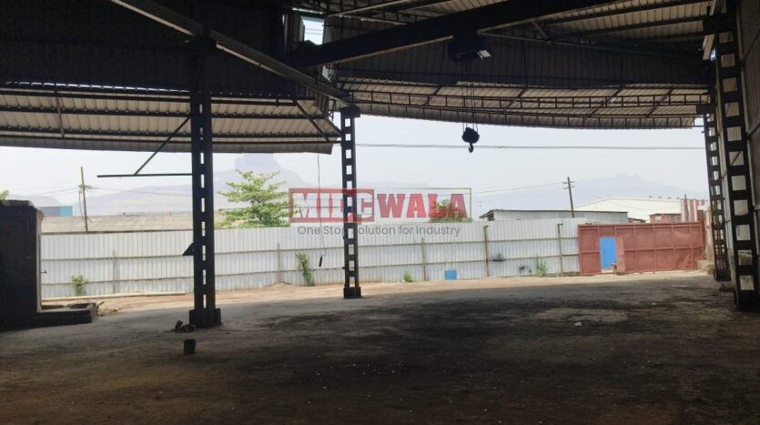 Alternative Text: Industrial shed for lease in Taloja Wavanje, Navi Mumbai. Large metal building with loading dock doors.