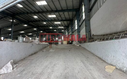 A spacious industrial warehouse with high ceilings and ample natural light, perfect for manufacturing and storage needs.