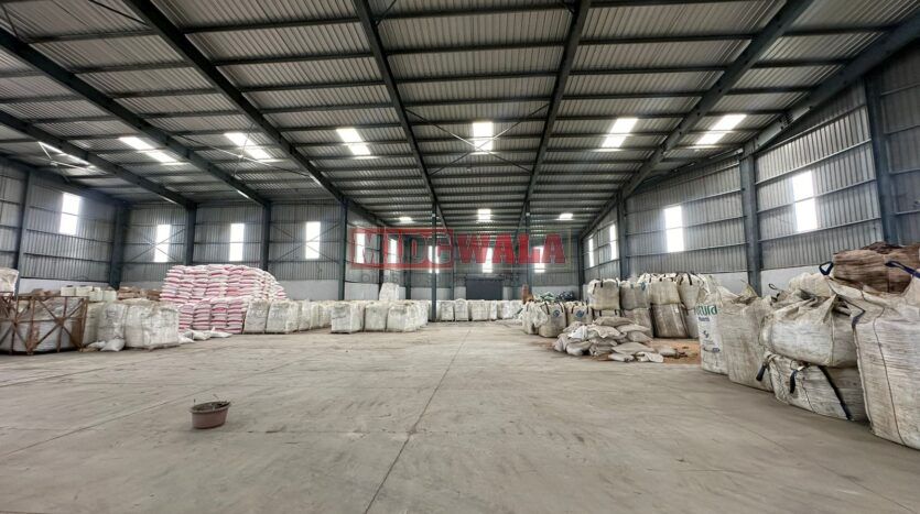 A spacious industrial warehouse with high ceilings and ample natural light, perfect for manufacturing and storage needs.